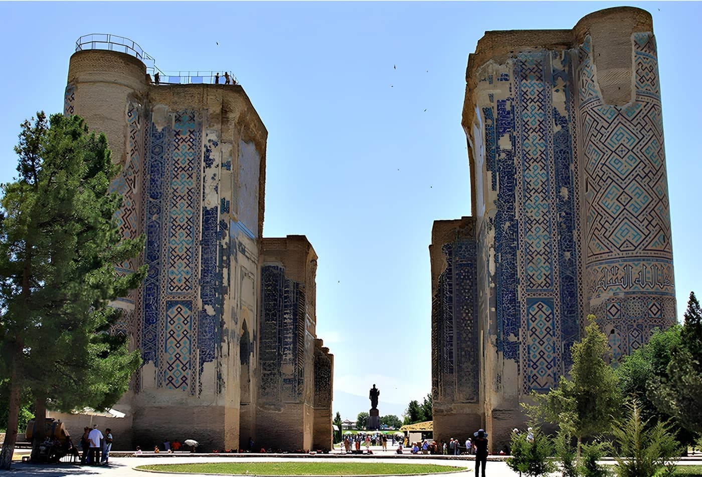 The two ruined pylons of the Ak-Saray portal, covered in blue tilework, with a park in front