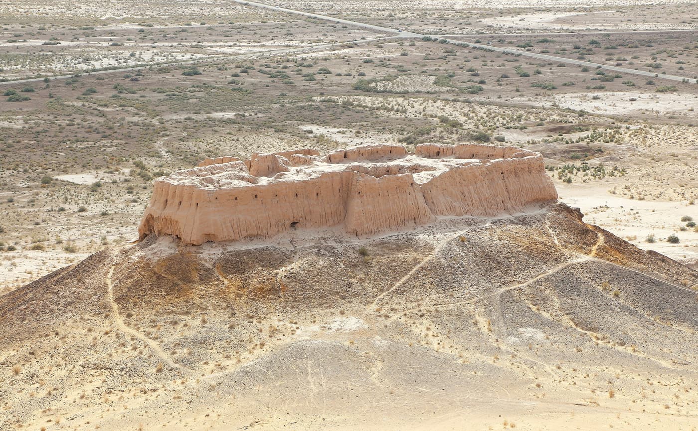Ayaz-Kala 2 from above: a small mud-brick fort on a cone-shaped hill in the desert