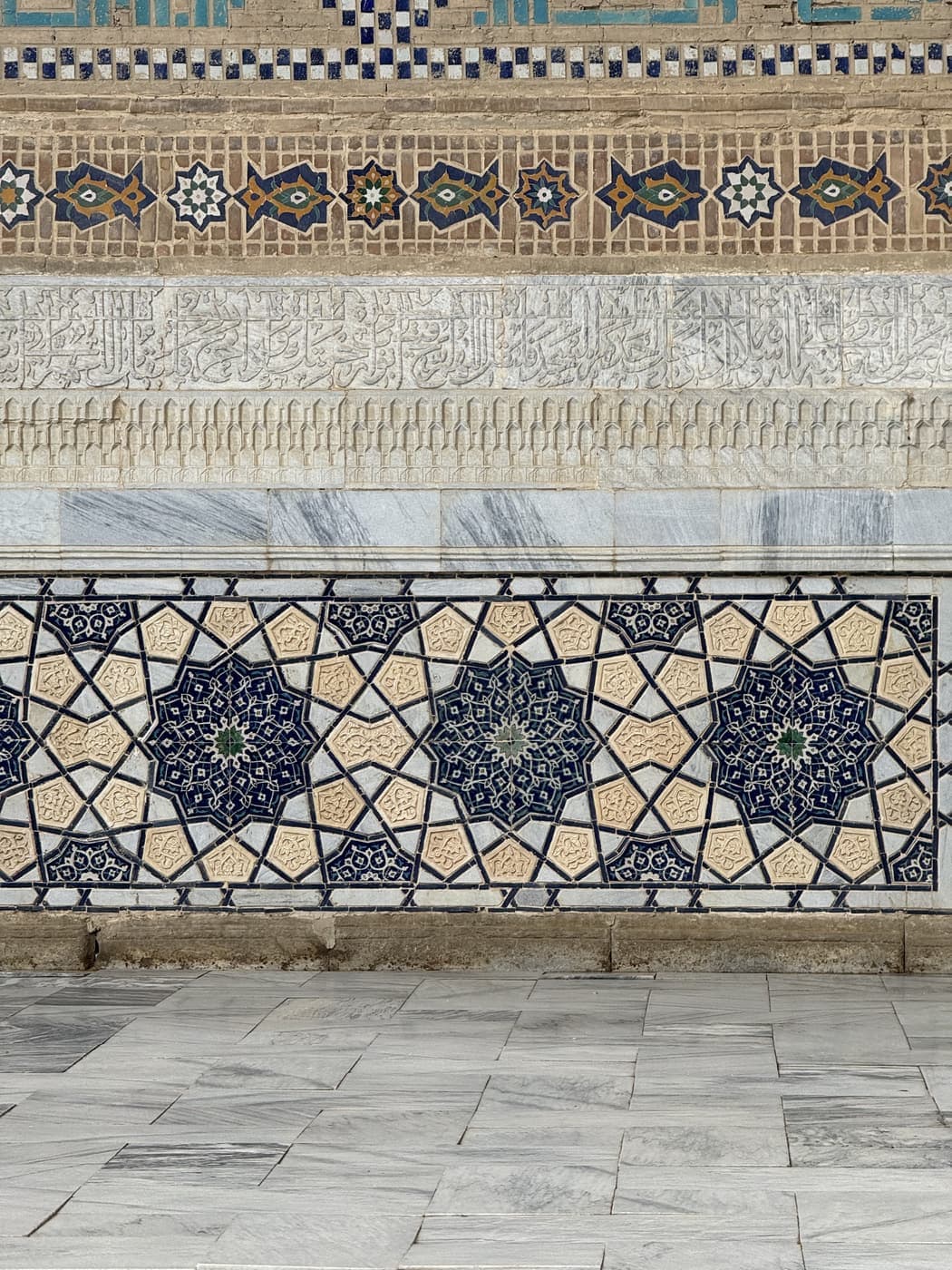 Detail of the mosque's exterior: carved marble below bands of glazed tile