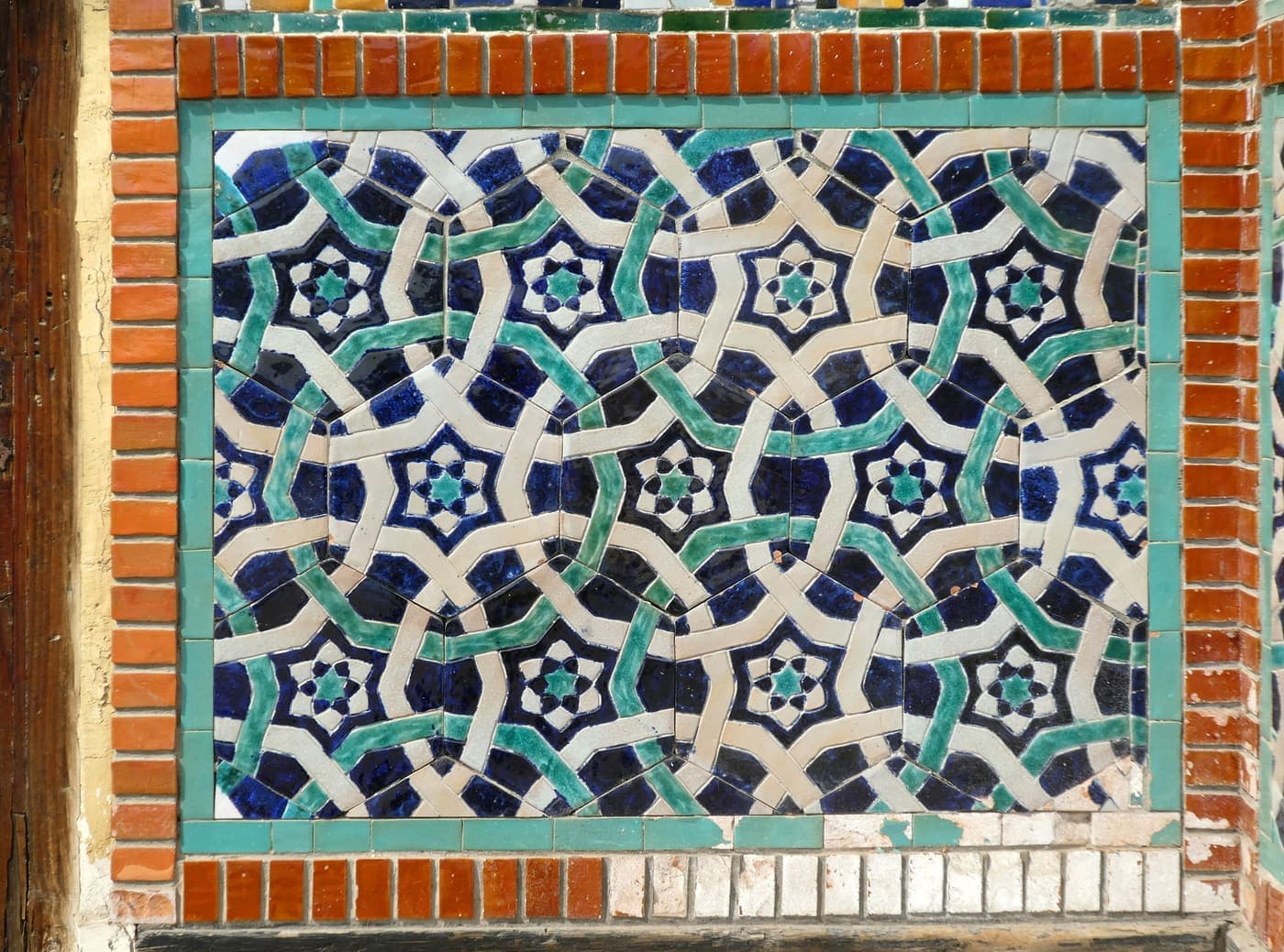 Close view of a majolica tile panel with a star pattern at the palace entrance