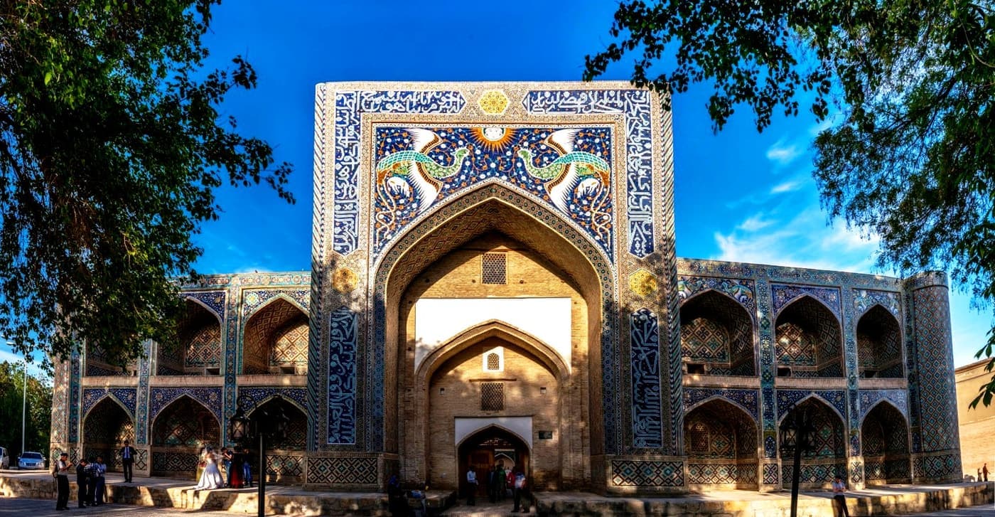 The madrasah facade under a deep blue sky